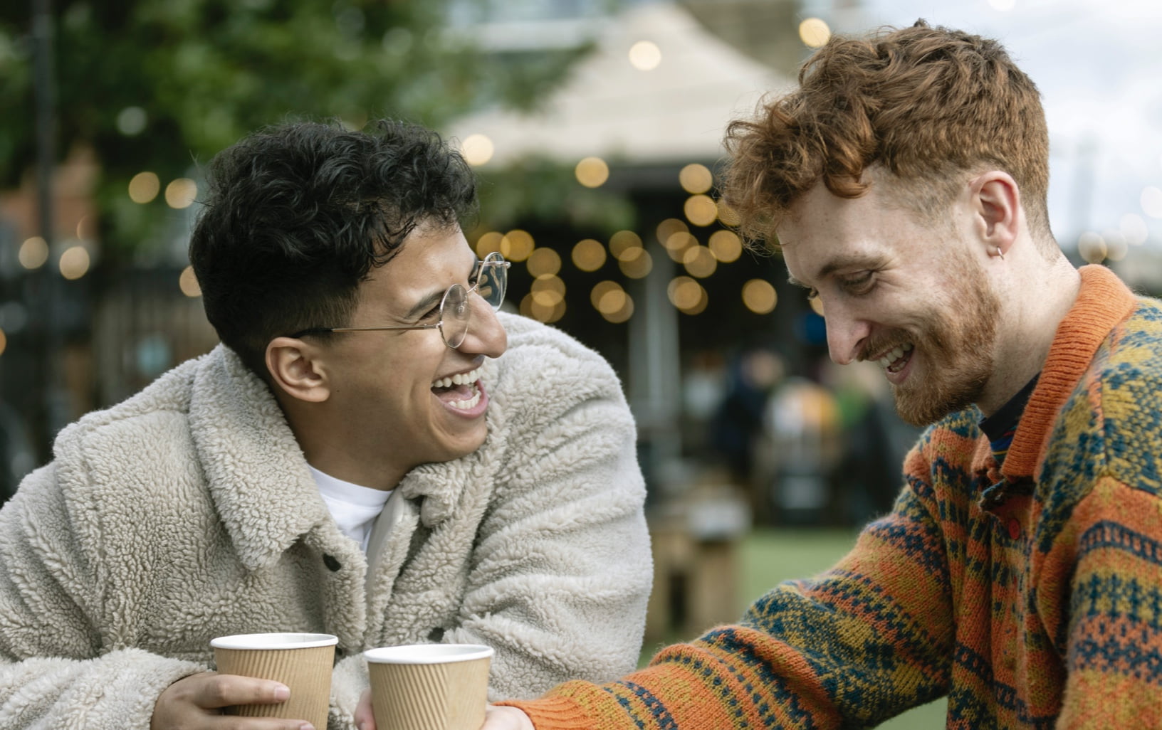 Two men having coffee and laughing together.